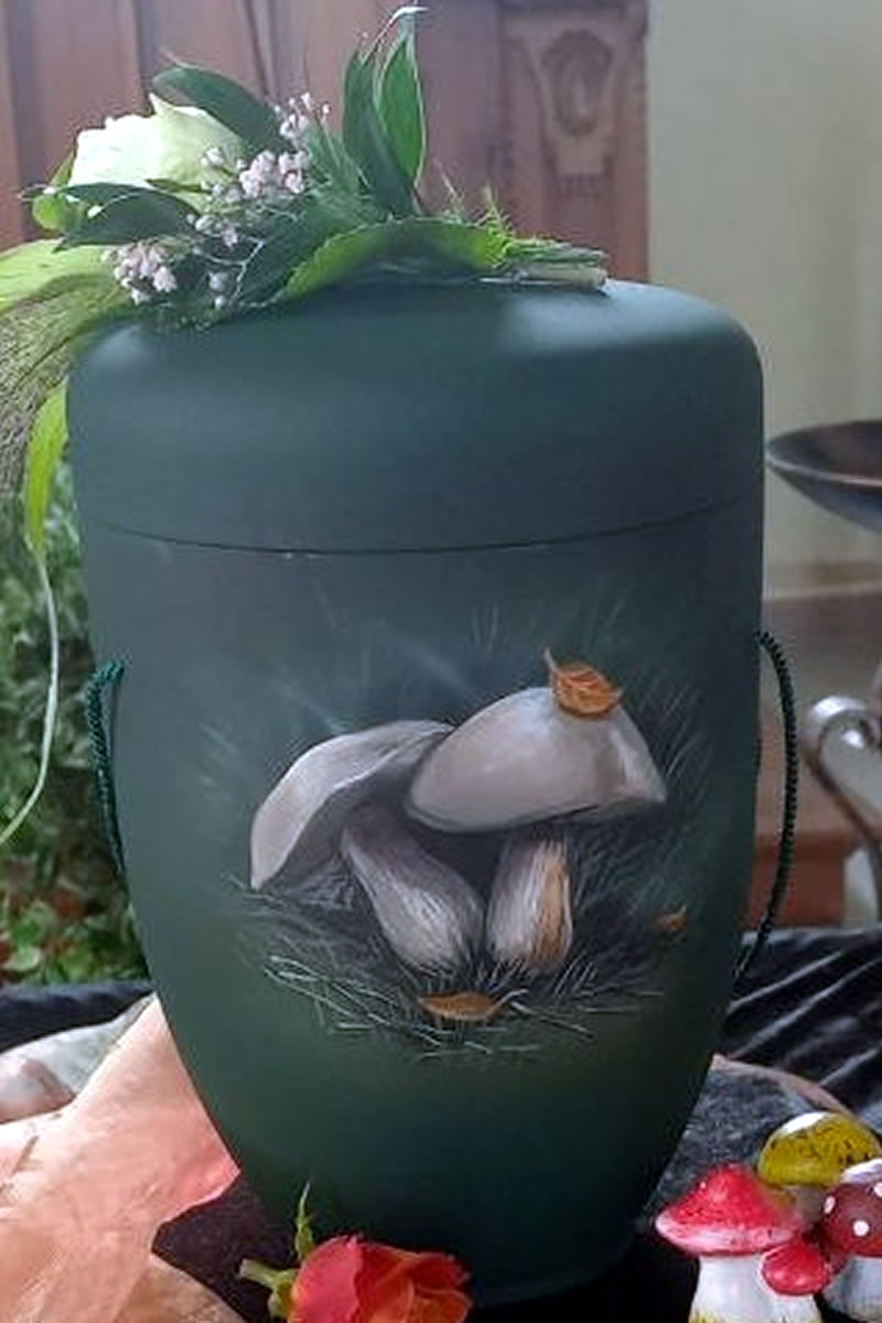 Eine olivgrüne Urne mit zwei Pilzen auf der Vorderseite Eine olivgrüne Urne mit zwei Pilzen auf der Vorderseite